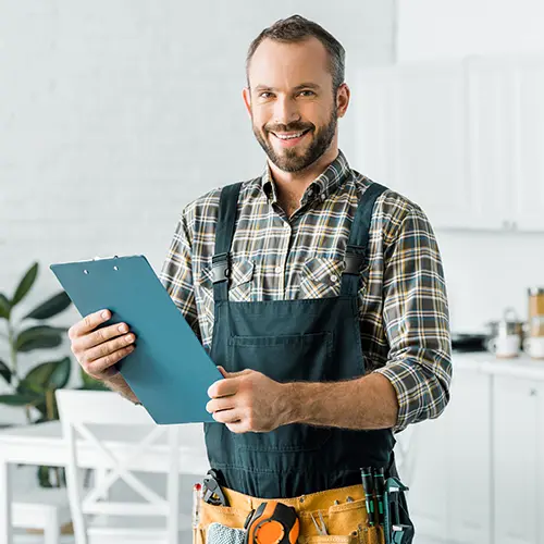 a smiling plumber holding a clipboard